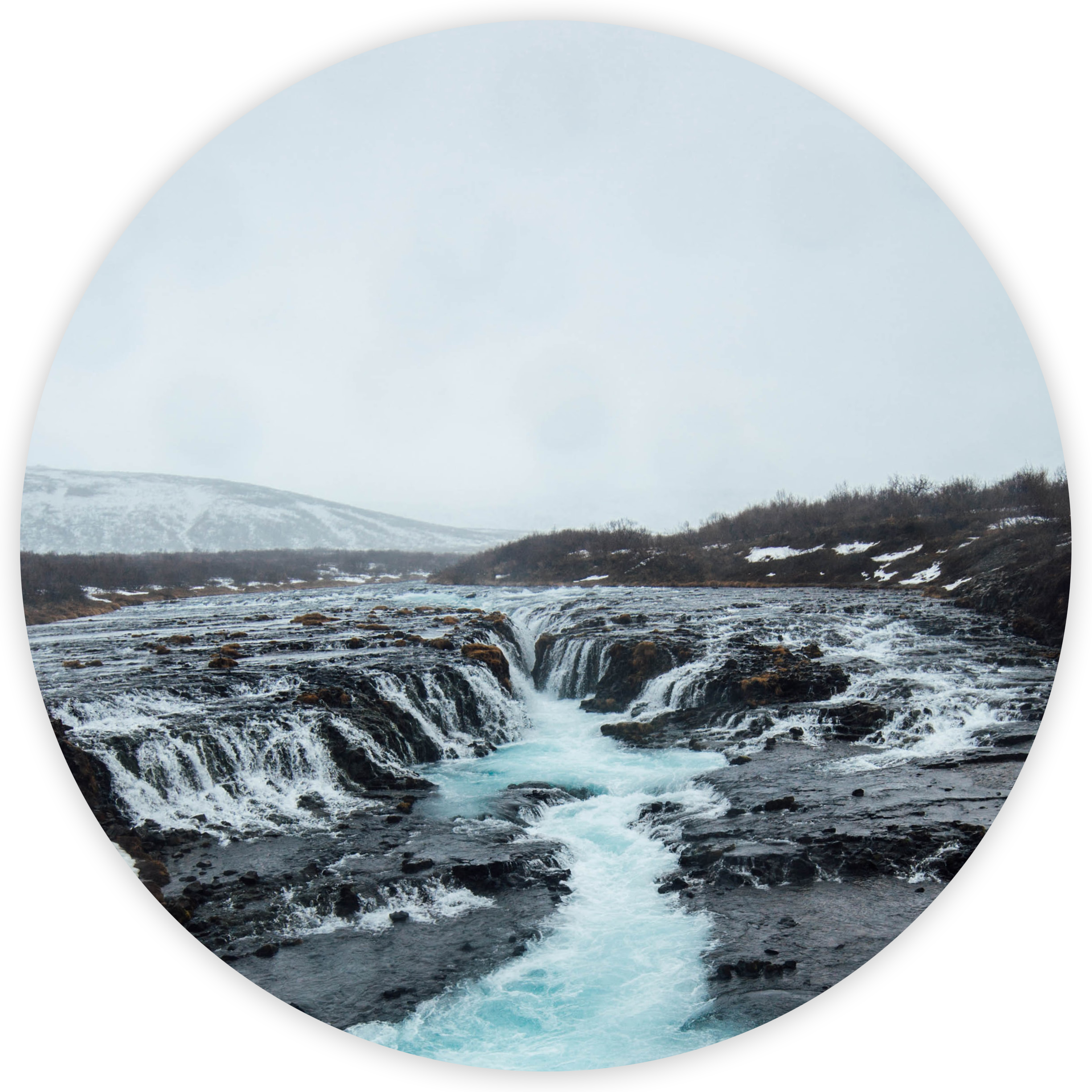 A roaring waterfall and river running between black rocks